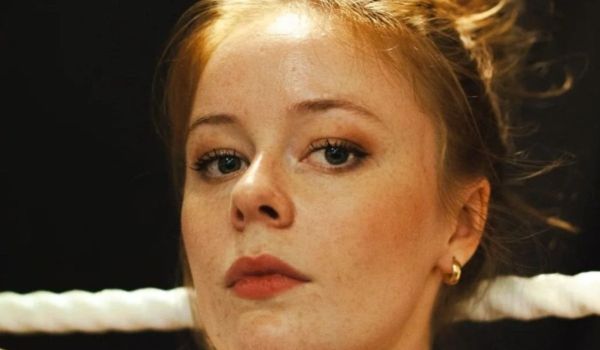Porträtt i närbild av Maja Fock med uppsatt hår och ett vitt rep i bakgrunden.