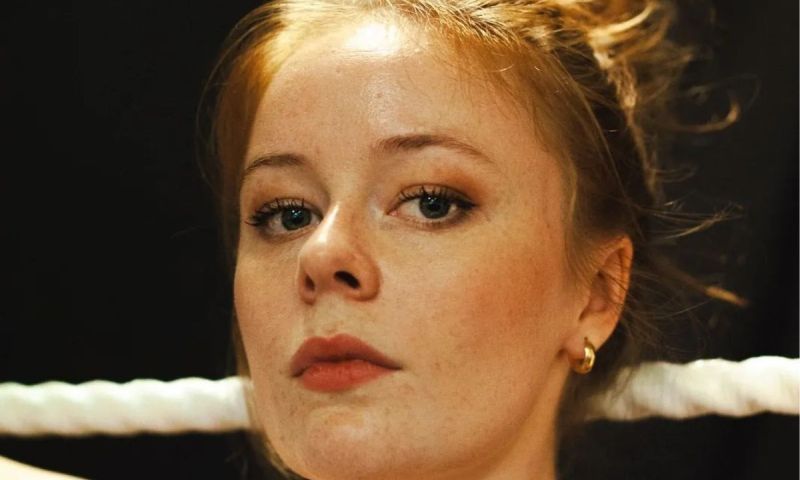 Porträtt i närbild av Maja Fock med uppsatt hår och ett vitt rep i bakgrunden.