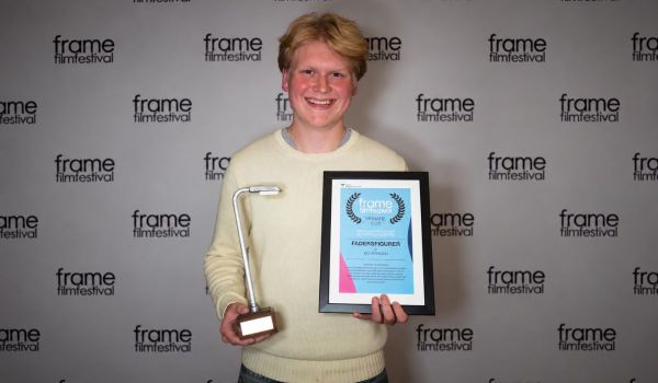 Bo Arnman leende med ett diplom och en statyett på Frame filmfestival.