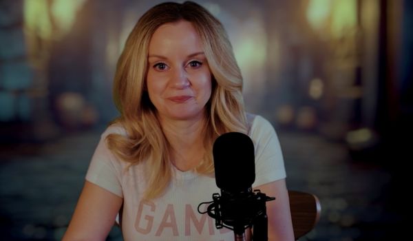 Person sitter vid ett bord i varm belysning och möter kameran med lugnt uttryck