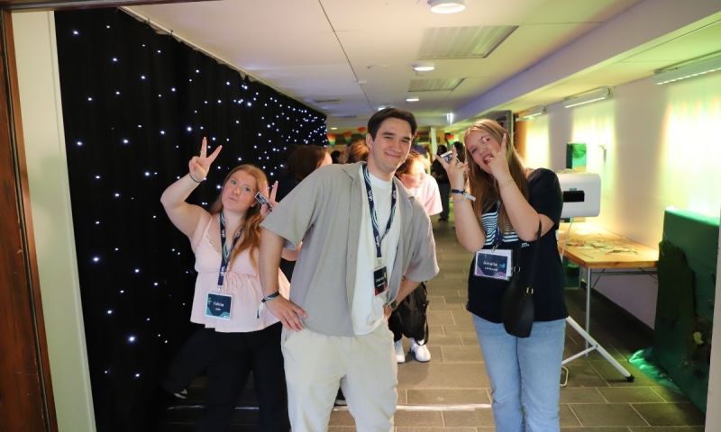 Tre unga personer poserar i en korridor med festivalpass