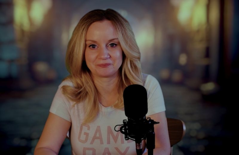 Person sitter vid ett bord i varm belysning och möter kameran med lugnt uttryck