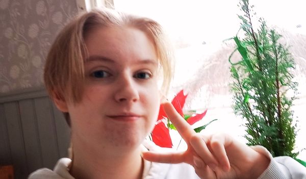 En selfie på Liam som gör ett fredstecken med fingrarna i en vardagsmiljö