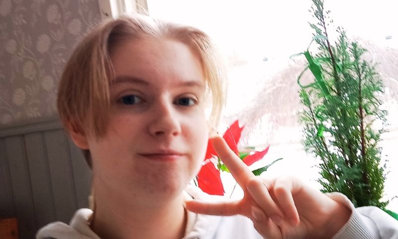 En selfie på Liam som gör ett fredstecken med fingrarna i en vardagsmiljö