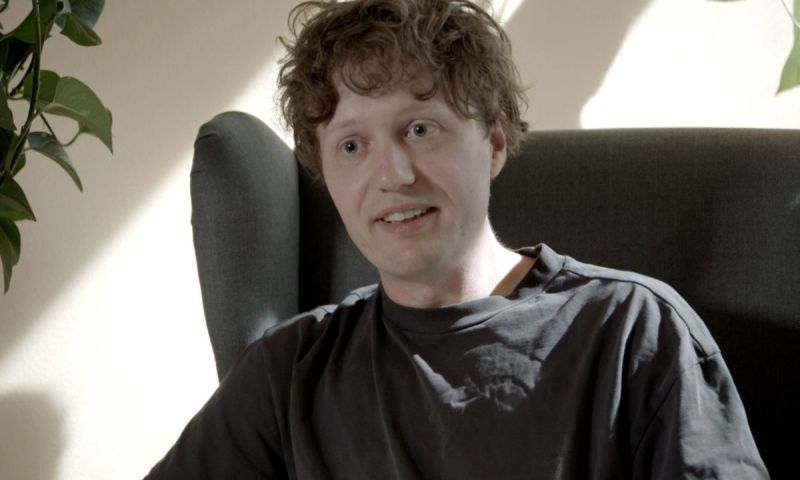 Truls, en man med lockigt hår sitter i en fåtölj och pratar.