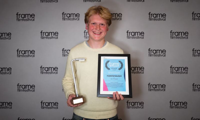Bo Arnman leende med ett diplom och en statyett på Frame filmfestival.