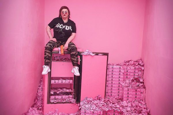 Person sitter på rosa pengar