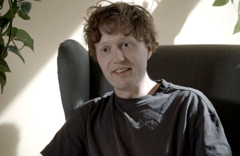 Truls, en man med lockigt hår sitter i en fåtölj och pratar.