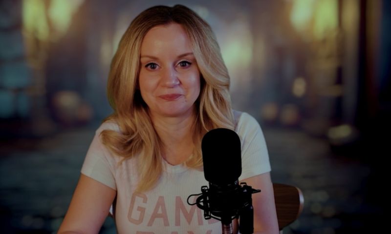 Person sitter vid ett bord i varm belysning och möter kameran med lugnt uttryck